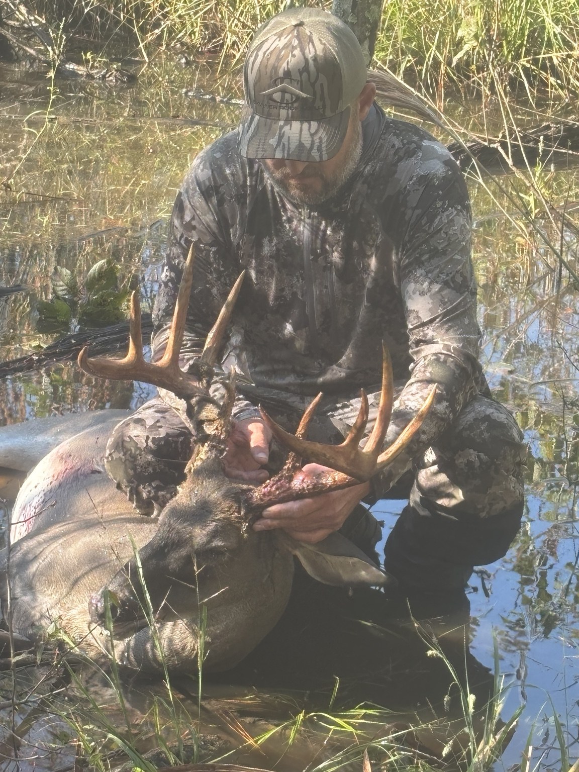 Customer with a harvested buck outdoors